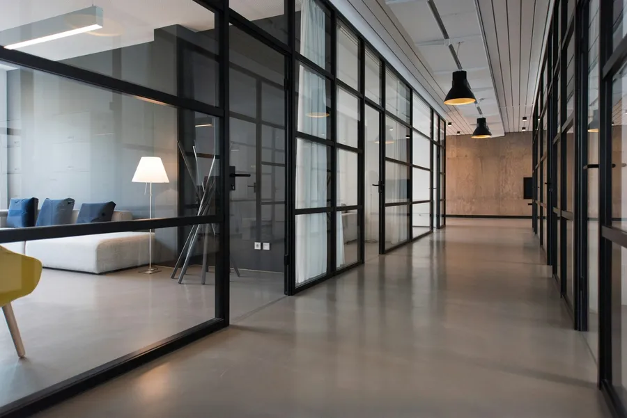 Pasillo de oficina con archivadores alineados contra la pared, iluminación fría y natural.